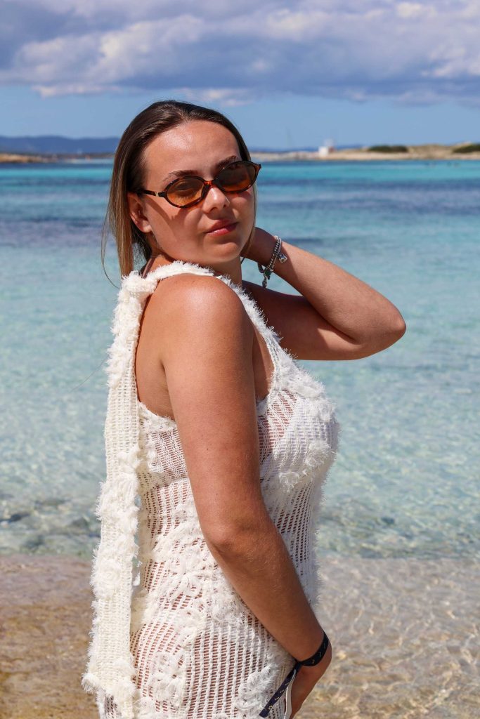 Frau mit weißem Kleid an Strand